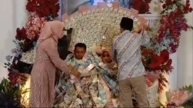 Pasangan pengantin di Bangkalan, Madura, berkalung uang ratusan dollar.