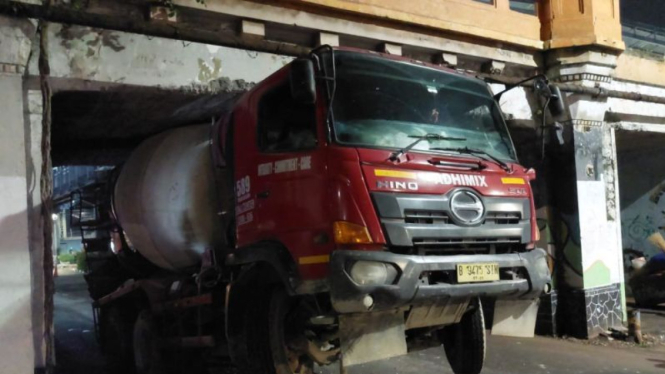 Truk molen tersangkut di kolong jembatan perlintasan rel kereta, Jalan Matraman