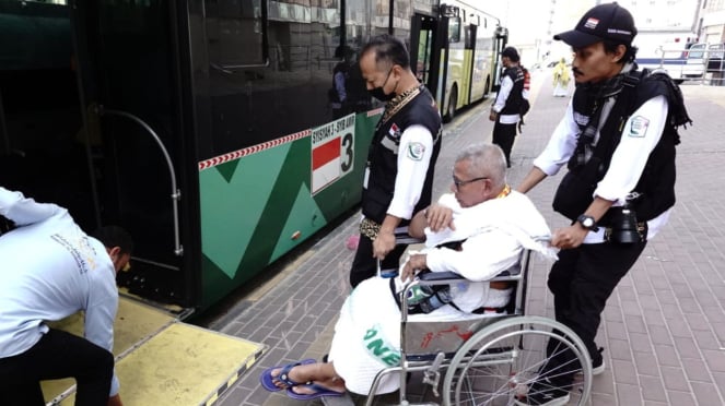 Los funcionarios ayudan a los peregrinos a abordar el autobús Shalawat a La Meca