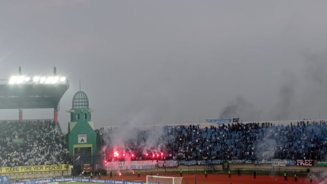 Bobotoh menyalakan flare di tribun selatan saat pertandingan Persib vs Persija (foto: Dede Idrus) 