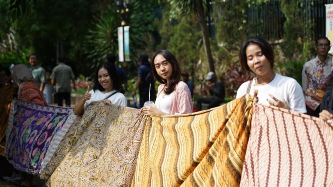 Pembentangan kain batik oleh siswa siswi sekolah di pendestrian Kebun Raya Bogor. 