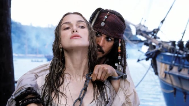 Keira Knightley berakting dengan Johnny Depp di film Pirates of The Caribbean.