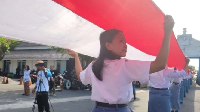 Para pelajar membentangkan bendera merah putih pada Hari Sumpah Pemuda