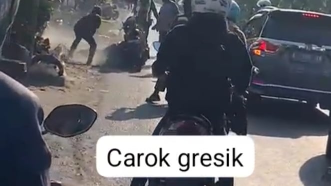 Captura de tela do vídeo de dois homens com armas afiadas na beira da estrada em Gresik. (Especial)