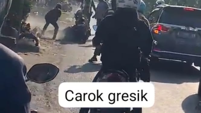 Tangkapan layar video 2 pria duel dengan senjata tajam di pinggir jalan Gresik. (Istimewa)