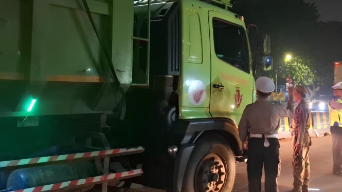 Petugas Polres Metro Tangerang Kota melakukan tindak tilang pada truk dalam penegakkan aturan jam operasional.