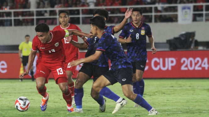 Perebutan bola saat laga Timnas Indonesia melawan Laos di pertandingan Grup B PIala AFF 2024 di Stadion Manahan Solo