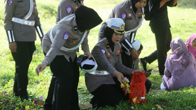 Polwan Polda Aceh menebar bunga di kuburan massal korban tsunami Aceh