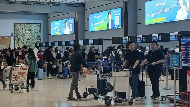 Antrian dan suasana pergerakan penumpang di konter check-in Terminal 2, Bandara Soekarno-Hatta, Tangerang