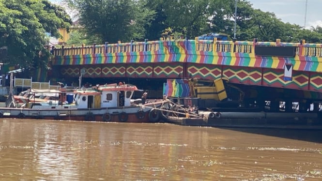 Kapal tongkang bermuatan tiang pancang dan alat berat menyangkut di jembatan Merdeka Kota Banjarmasin.