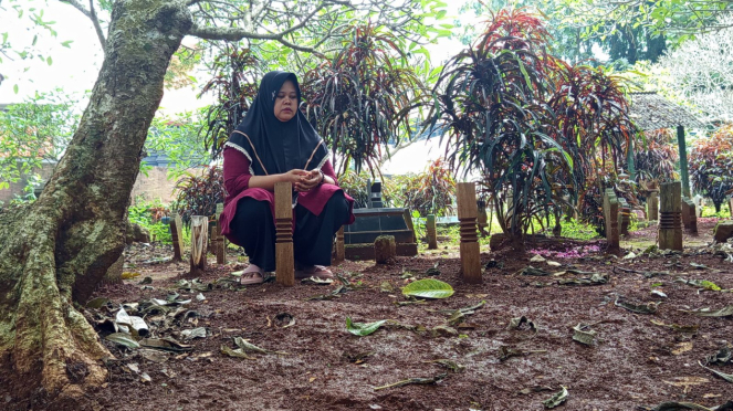 Poniyem saat di makam suaminya yang tewas diduga dianiaya polisi di Semarang 