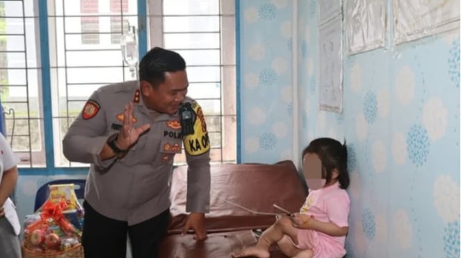 Kapolres AKBP. Ferry Mulyana Sunarya saat bertemu dengan bocah 10 tahun yang viral diduga dianiaya.(dok Polres Nias Selatan)