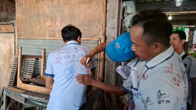 Aksi tanda tangan di seragam karyawan Sritex untuk kenang-kenangan pasca PHK masal.