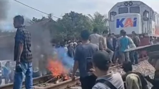 Sekelompok warga saat adang laju kereta dengan bakar ban di Kabupaten Batubara.(tangkap layar)