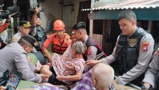 Momen Perwira Polisi Berjibaku Evakuasi Lansia Sakit Stroke Terjebak Banjir di Cengkareng