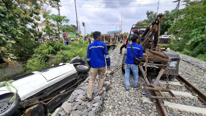 Petugas mobil derek mengevakuasi mobil Sigra yang ditabrak KA Batara Kresna di palang pintu perlintasan kereta di Kelurahan Gayam, Sukoharjo.