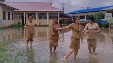 Aksi Kepsek di Kabupaten Karo yang viral di media sosial, bermain air saat banjir di sekolah.(tangkap layar)