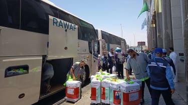 Koper-koper jemaah gelombang 2 diturunkan dari bus untuk dibawa ke kamar hotel