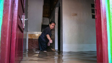Warga Jakarta di rumahnya yang terendam banjir.