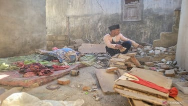 Residentes de Situbondo afectados por el terremoto limpiando las ruinas del edificio